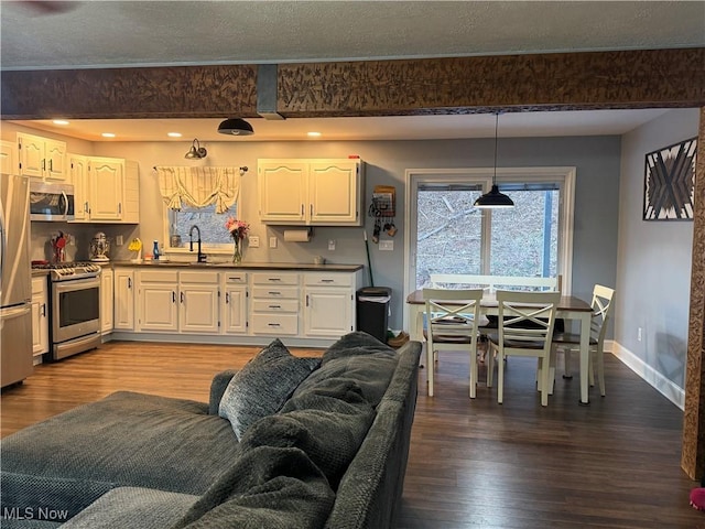 kitchen featuring sink, stainless steel appliances, white cabinetry, and hardwood / wood-style floors