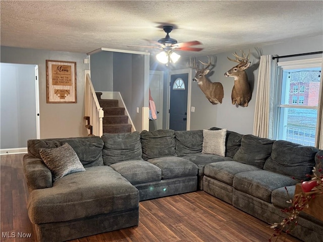 living room featuring a textured ceiling, dark hardwood / wood-style floors, and ceiling fan