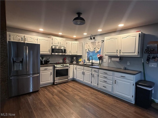 kitchen featuring white cabinets, stainless steel appliances, dark wood-type flooring, and sink