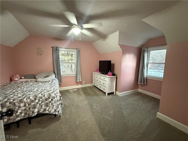 carpeted bedroom featuring vaulted ceiling, ceiling fan, and a textured ceiling