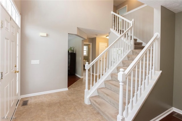 tiled foyer with a wealth of natural light and a towering ceiling