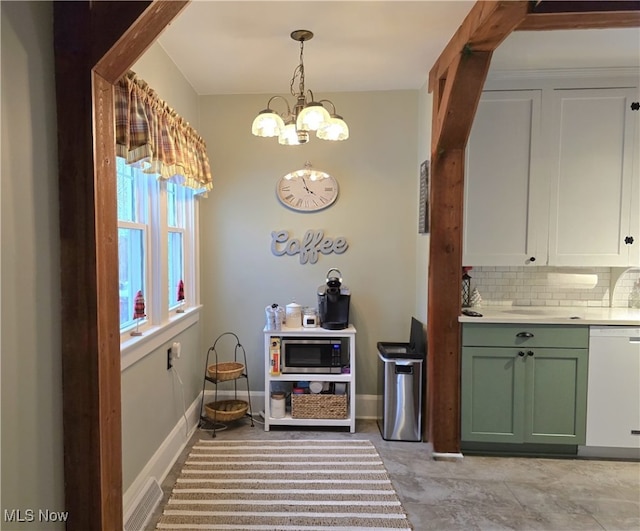 kitchen with backsplash, white dishwasher, white cabinets, stainless steel microwave, and pendant lighting