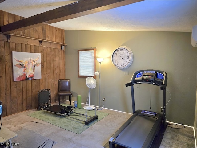 exercise area featuring vaulted ceiling and wood walls