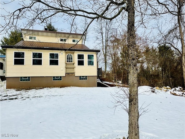 snow covered property with metal roof