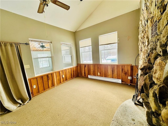 empty room featuring a baseboard radiator, a wainscoted wall, and plenty of natural light