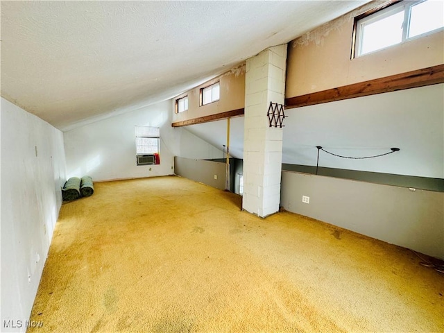 bonus room featuring lofted ceiling, a textured ceiling, cooling unit, and carpet flooring