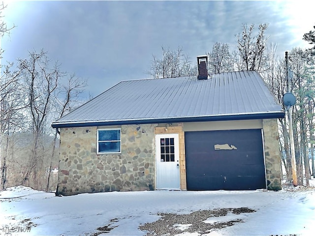 exterior space with stone siding, metal roof, and a chimney