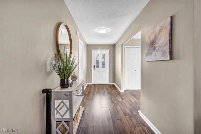 doorway featuring dark hardwood / wood-style flooring and a textured ceiling