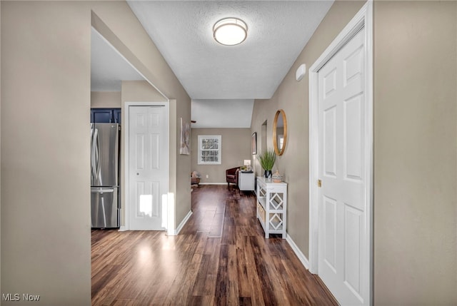 hall featuring a textured ceiling and dark wood-type flooring