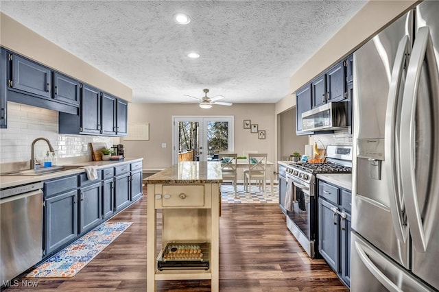 kitchen featuring appliances with stainless steel finishes, sink, and blue cabinetry