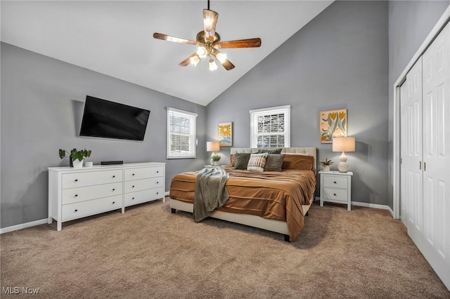 bedroom with a closet, high vaulted ceiling, light colored carpet, and ceiling fan