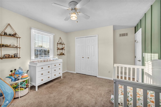 carpeted bedroom featuring ceiling fan, a textured ceiling, and a closet