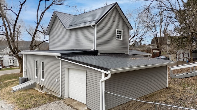 view of side of home featuring a garage and central AC