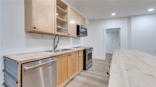 kitchen featuring light hardwood / wood-style floors, sink, wood counters, appliances with stainless steel finishes, and light brown cabinets