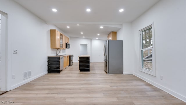 kitchen featuring sink, appliances with stainless steel finishes, light brown cabinets, and light hardwood / wood-style flooring