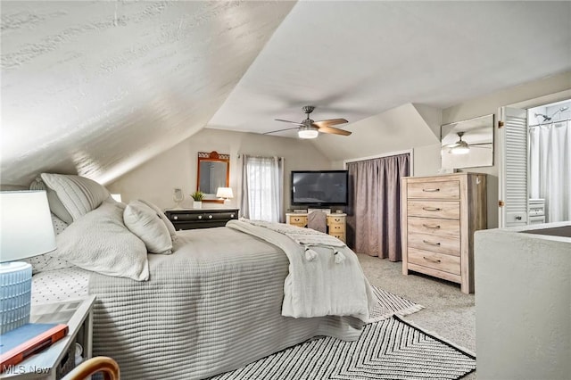 carpeted bedroom featuring ceiling fan and vaulted ceiling