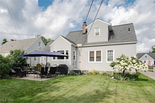 back of house with a patio area and a yard