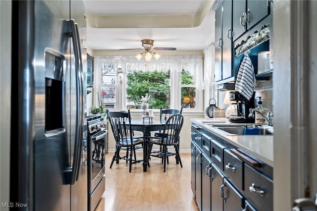 kitchen with ceiling fan, sink, stainless steel appliances, and light wood-type flooring