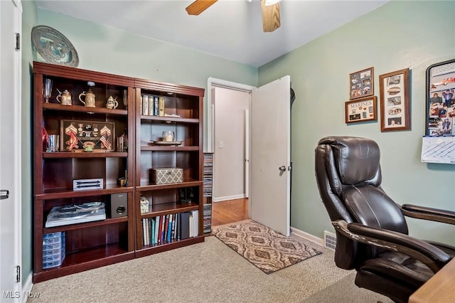 carpeted office with ceiling fan