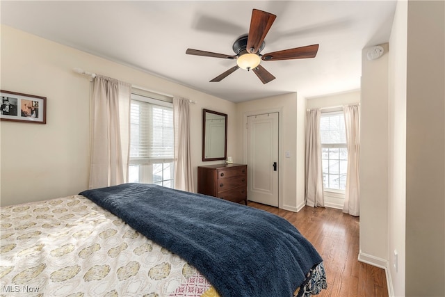 bedroom featuring ceiling fan, baseboards, and wood finished floors