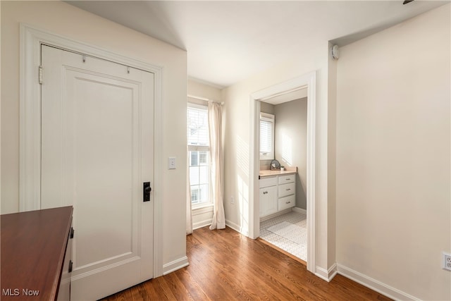 hallway with wood finished floors and baseboards