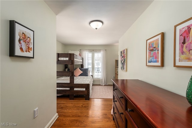 bedroom with dark wood-style flooring and baseboards