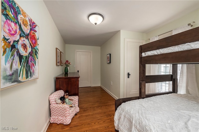 bedroom with baseboards and wood finished floors