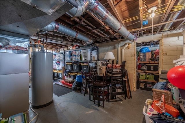 unfinished below grade area featuring gas water heater, concrete block wall, and heating unit