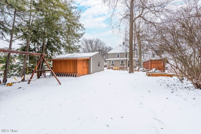 snow covered rear of property with an outbuilding and a storage unit