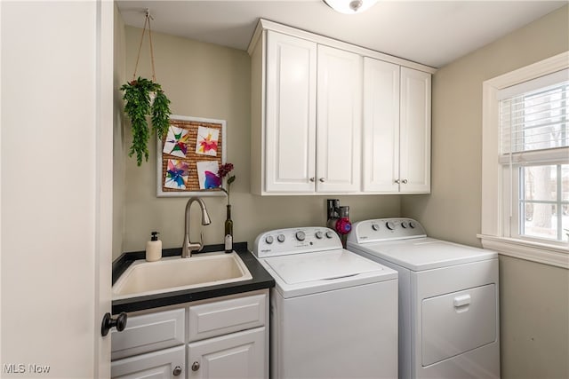 washroom with a sink, cabinet space, and washer and dryer