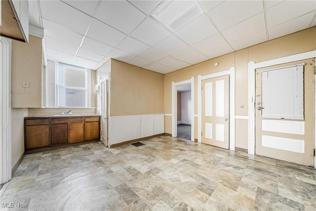 unfurnished room with sink and a drop ceiling