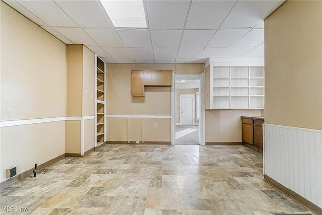 spare room featuring a paneled ceiling and built in shelves