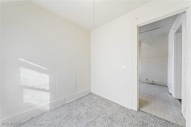 empty room featuring light carpet and lofted ceiling