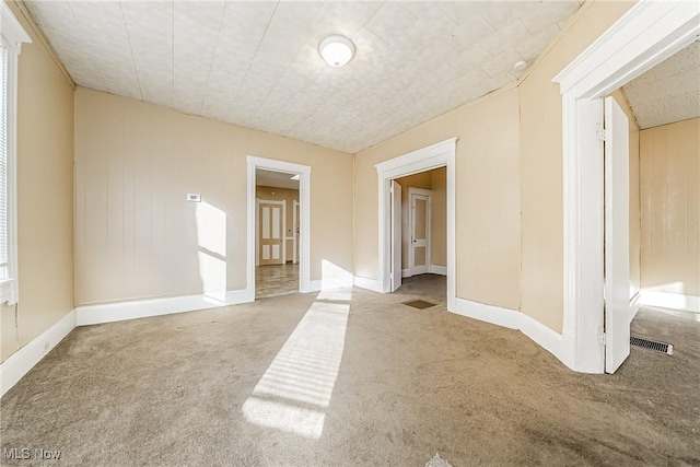 carpeted spare room with wooden walls