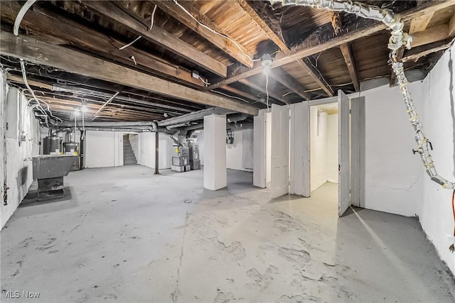 basement with electric water heater, heating unit, and water heater