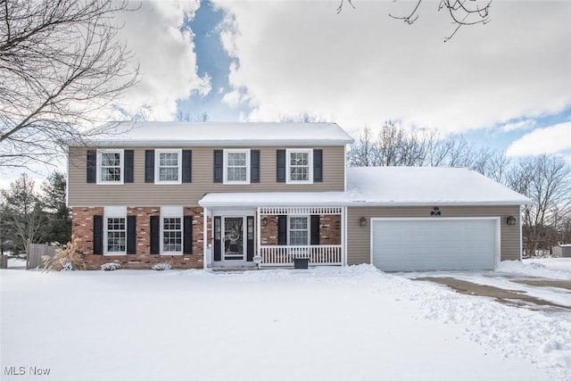 colonial inspired home featuring brick siding, an attached garage, and covered porch