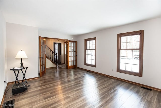 interior space featuring dark wood finished floors, baseboards, french doors, and visible vents