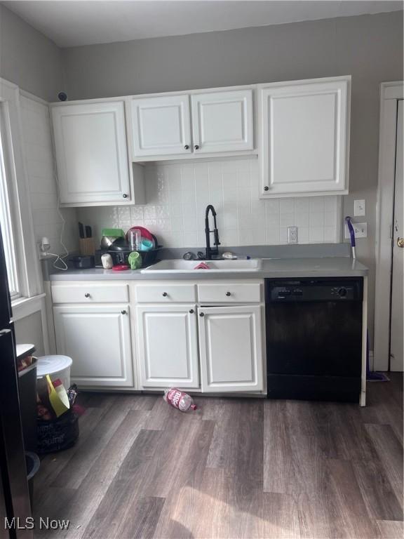 kitchen with dark wood finished floors, white cabinetry, a sink, and black dishwasher