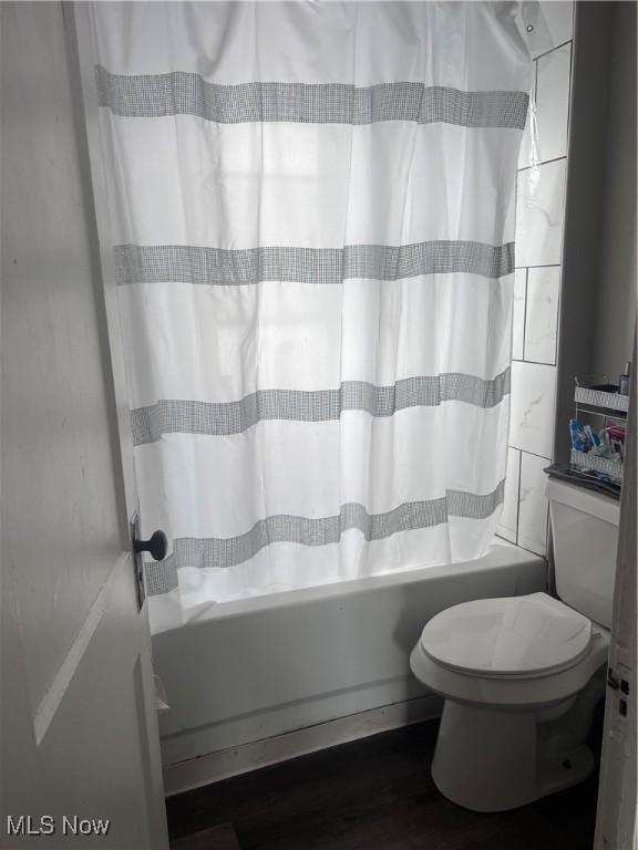 bathroom featuring shower / bath combo, wood finished floors, and toilet