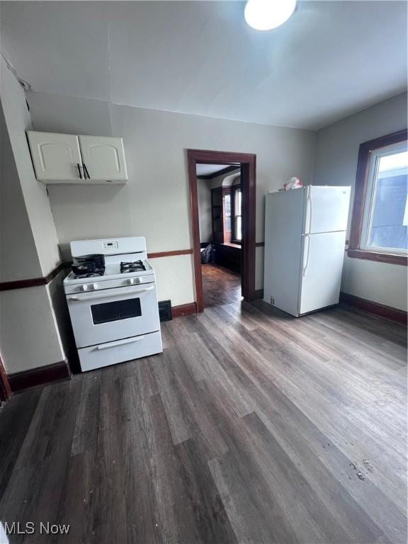 kitchen featuring white cabinetry, white appliances, a wealth of natural light, and dark wood-style floors