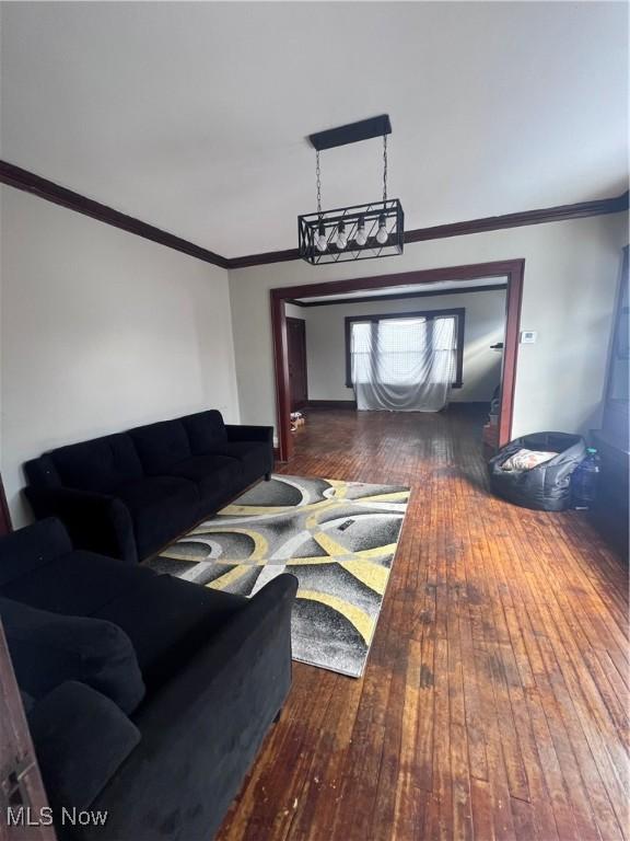 living area featuring wood finished floors and ornamental molding