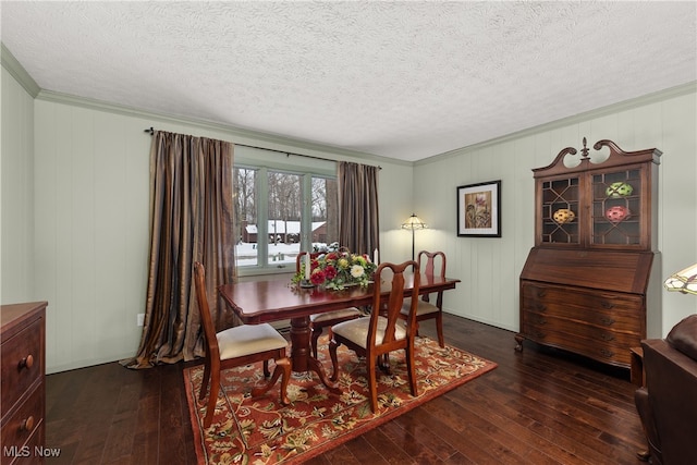 dining room featuring dark wood-style floors, crown molding, and a textured ceiling