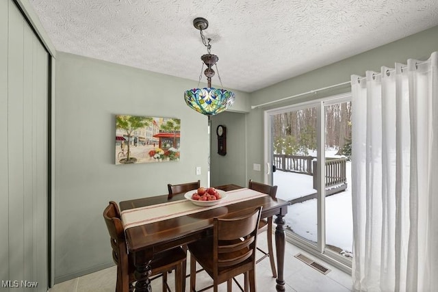 dining space featuring visible vents and a textured ceiling