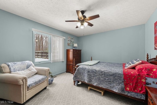 bedroom with a ceiling fan, light carpet, and a textured ceiling