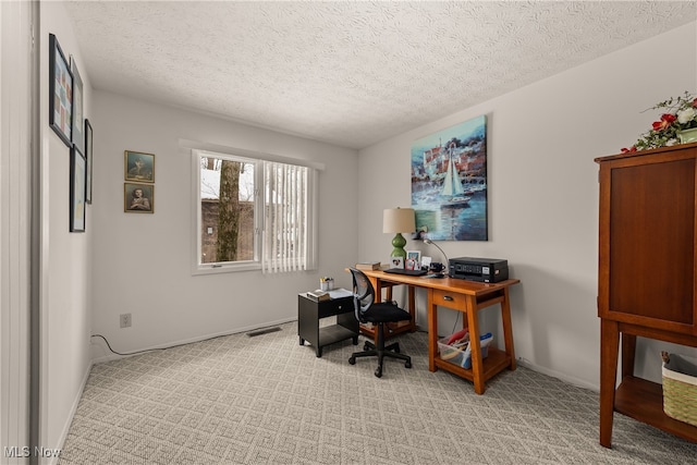 office area with visible vents, light colored carpet, and a textured ceiling