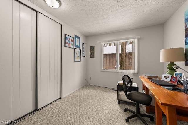 office with light carpet, a textured ceiling, and baseboards