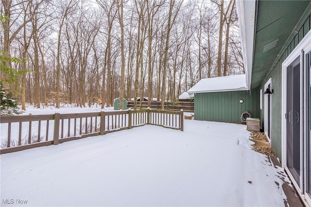 snow covered deck featuring fence