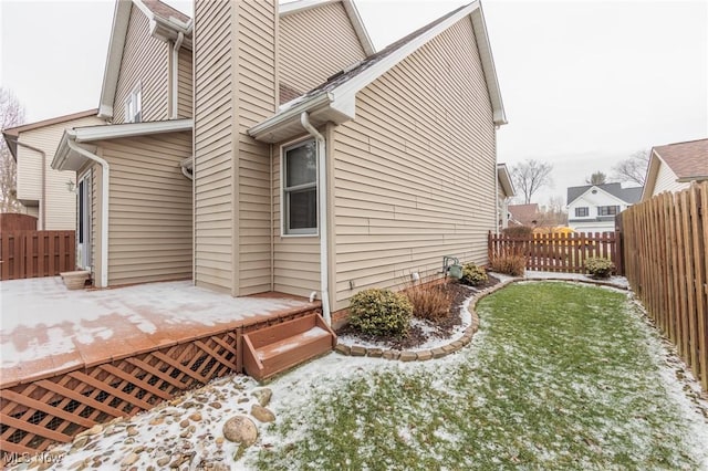 snow covered property featuring a lawn and a fenced backyard