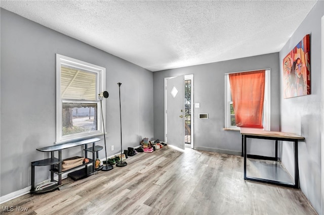 entrance foyer with a textured ceiling and light hardwood / wood-style floors