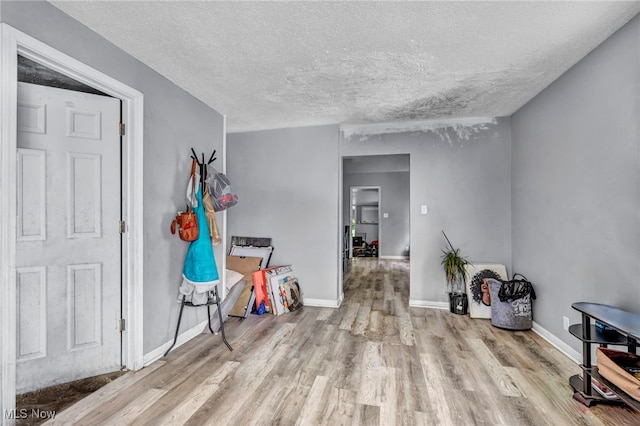 interior space with a textured ceiling and light hardwood / wood-style floors